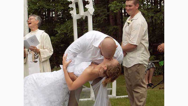 From wedding 3, Niagara DJ, Groom dipping bride half way back for a very romantic you may now kiss the bride. Woman minister in background laughing. Taken in Niagara Ontario